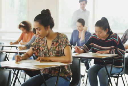 Teilnehmer schreiben konzentriert die A2 Deutsch Pr&uuml;fung im Klassenzimmer, offizieller Sprachtest f&uuml;r Anf&auml;nger mit Grundkenntnissen.