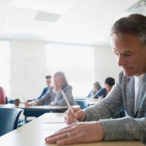 Teilnehmer absolviert konzentriert die C1 telc Deutsch Prüfung im Klassenzimmer, offizieller Sprachtest für fortgeschrittenes Niveau.