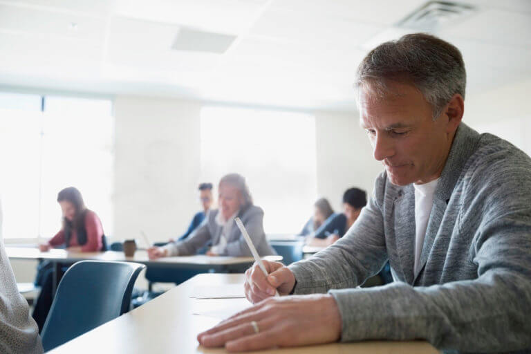 Teilnehmer absolviert konzentriert die C1 telc Deutsch Pr&uuml;fung im Klassenzimmer, offizieller Sprachtest f&uuml;r fortgeschrittenes Niveau.